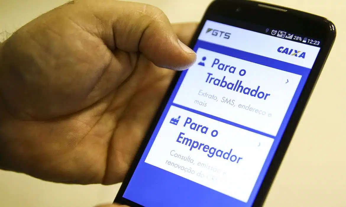 A imagem mostra uma pessoa acessando o aplicativo do FGTS para solicitar o saque extraordinário