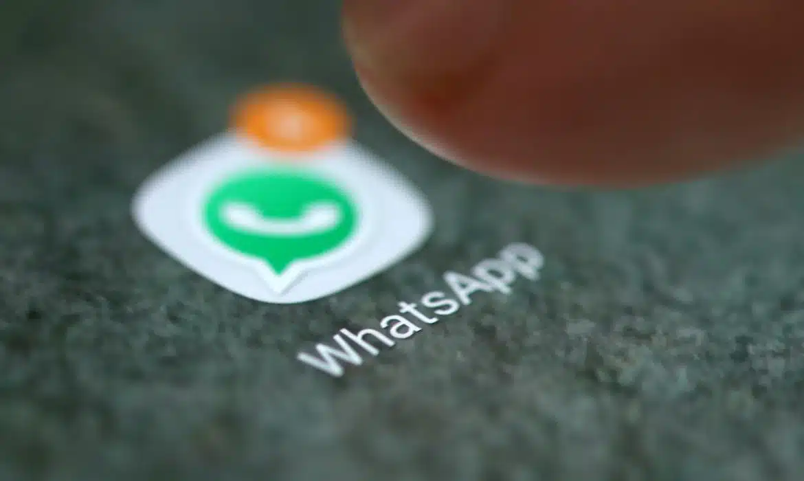 A imagem mostra pessoa abrindo o WhatsApp no celular