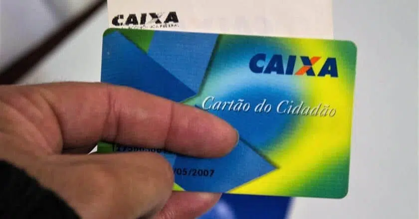 Foto mostra pessoa segurando Cartão Cidadão da Caixa Econômica Federal.