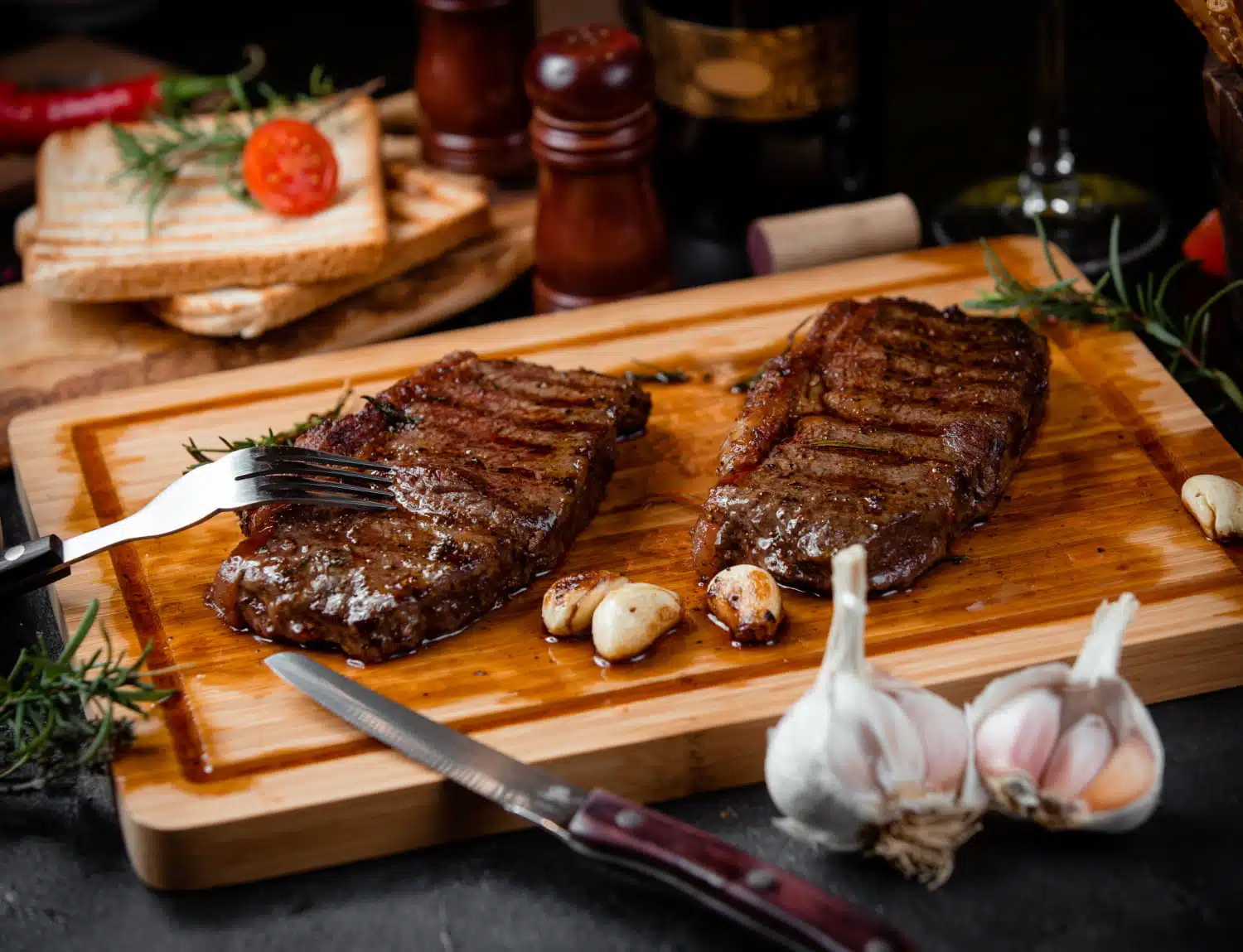 A imagem mostra uma tábua de corte com duas carnes assadas