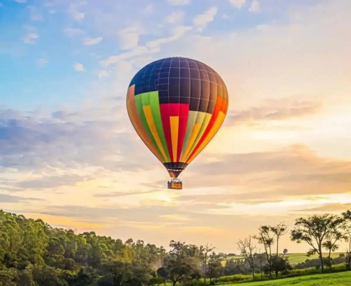 Na imagem, um balão colorido voando no céu