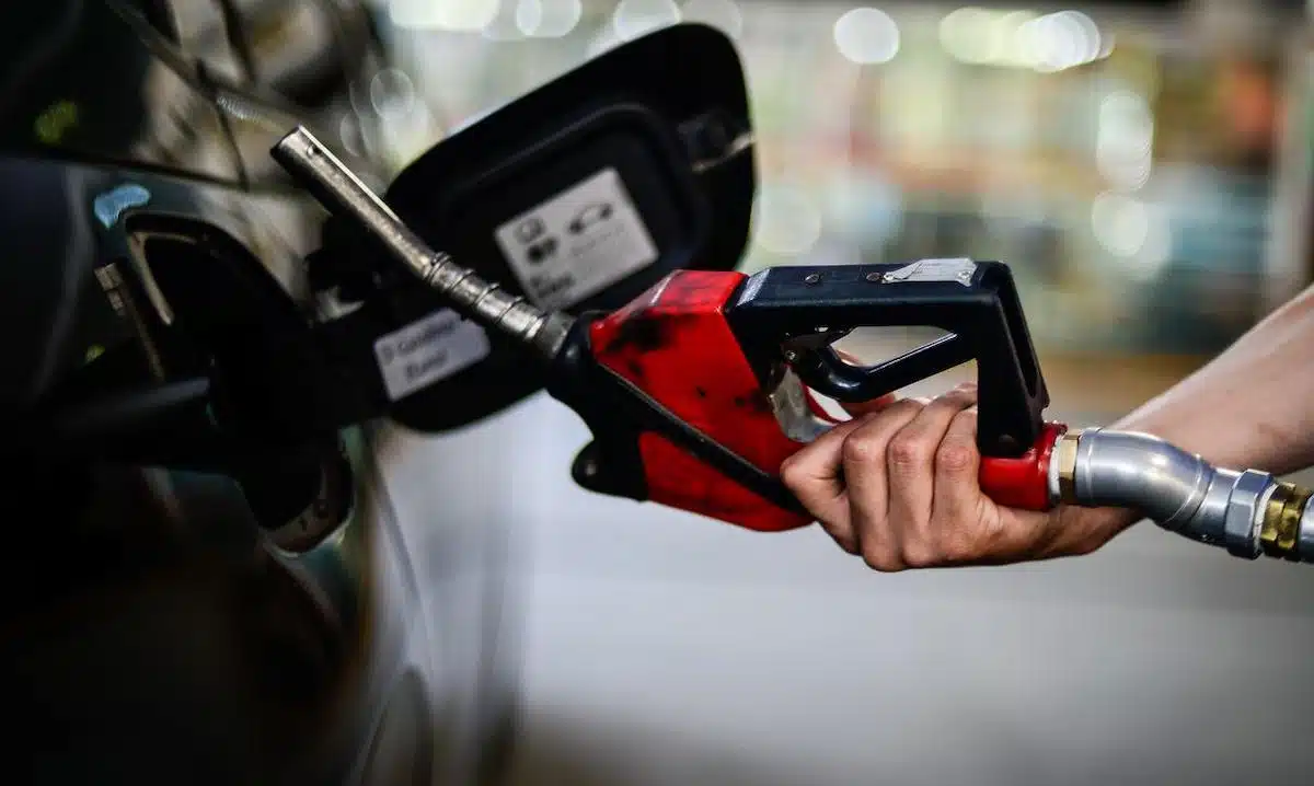 Foto mostra pessoa abastecendo veículo em posto de gasolina.