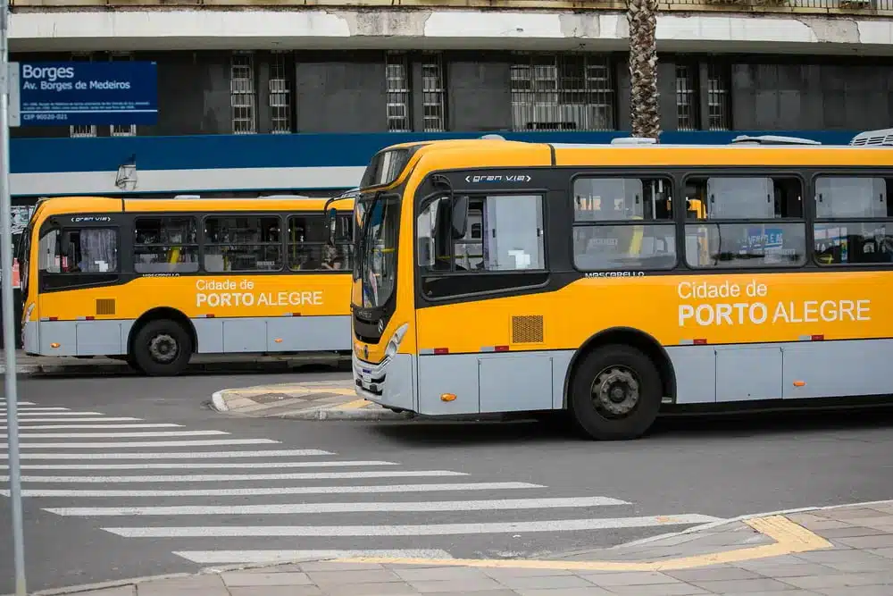 Na imagem, dois ônibus de Porto Alegre na rua