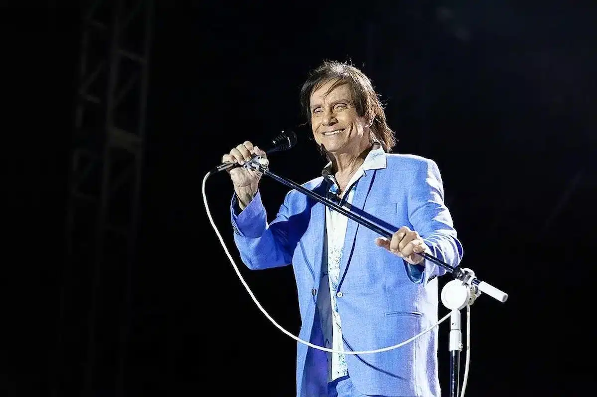 Foto mostra o cantor Roberto Carlos em apresentação ao vivo.