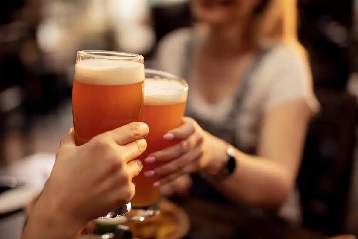 Foto mostra duas pessoas brindando um copo de cerveja, em uma representação da Oktoberfest.