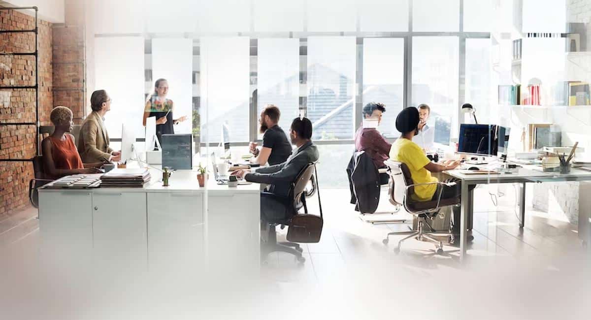 Foto mostra pessoas reunidas em reunião empresarial, em diversas mesas separadas. Imagem ilustrativa de uma startup.