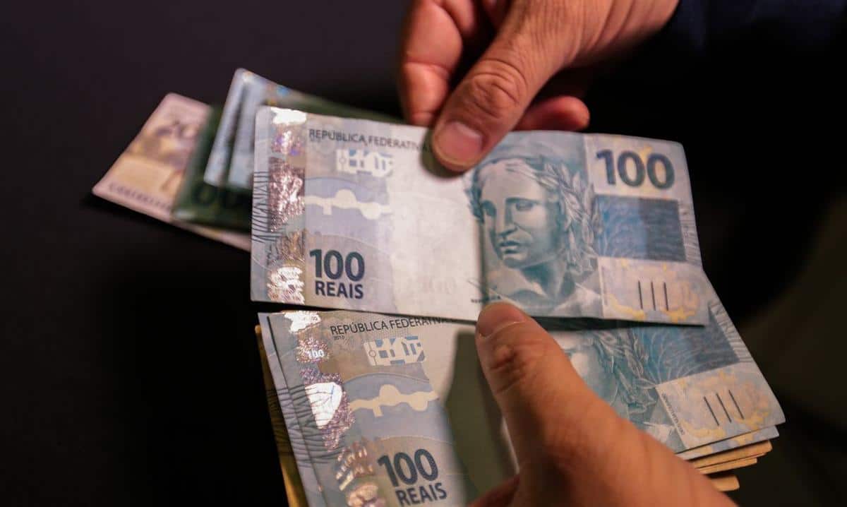 Foto mostra cédulas de R$ 100, representando pagamento do 13º do INSS.