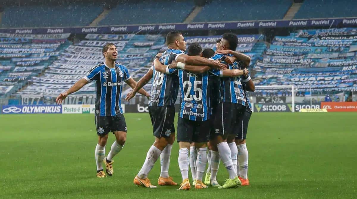 Jogadores do Grêmio reunidos durante partida.