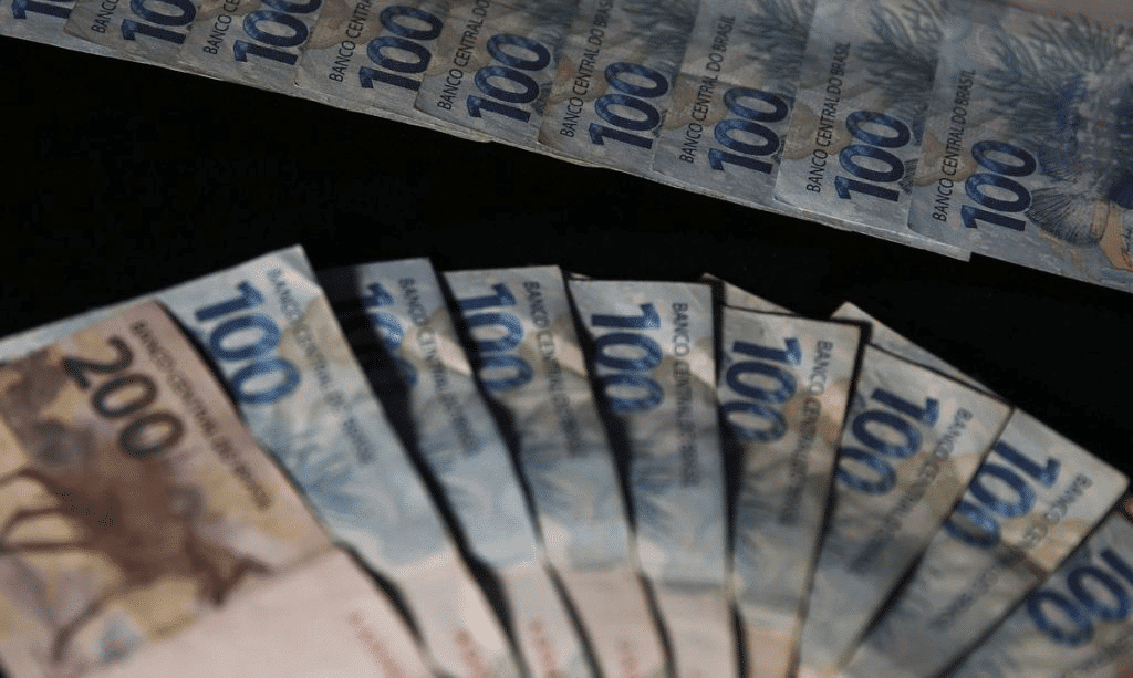Foto mostra notas de dinheiro, uma representação do auxílio milionário enviado ao RS.