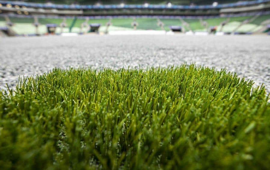 Foto mostra um gramado em um campo de futebol.