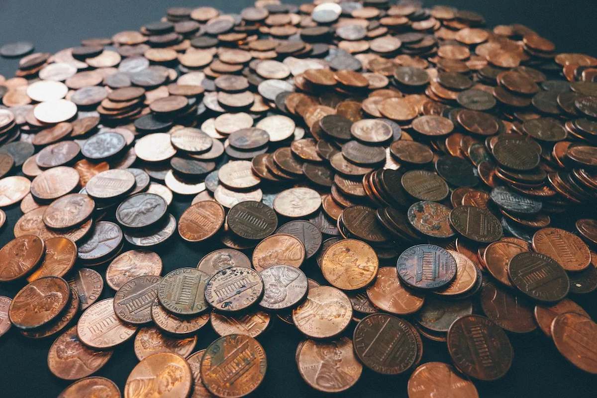Foto mostra uma série de moedas acumuladas em uma superfície.