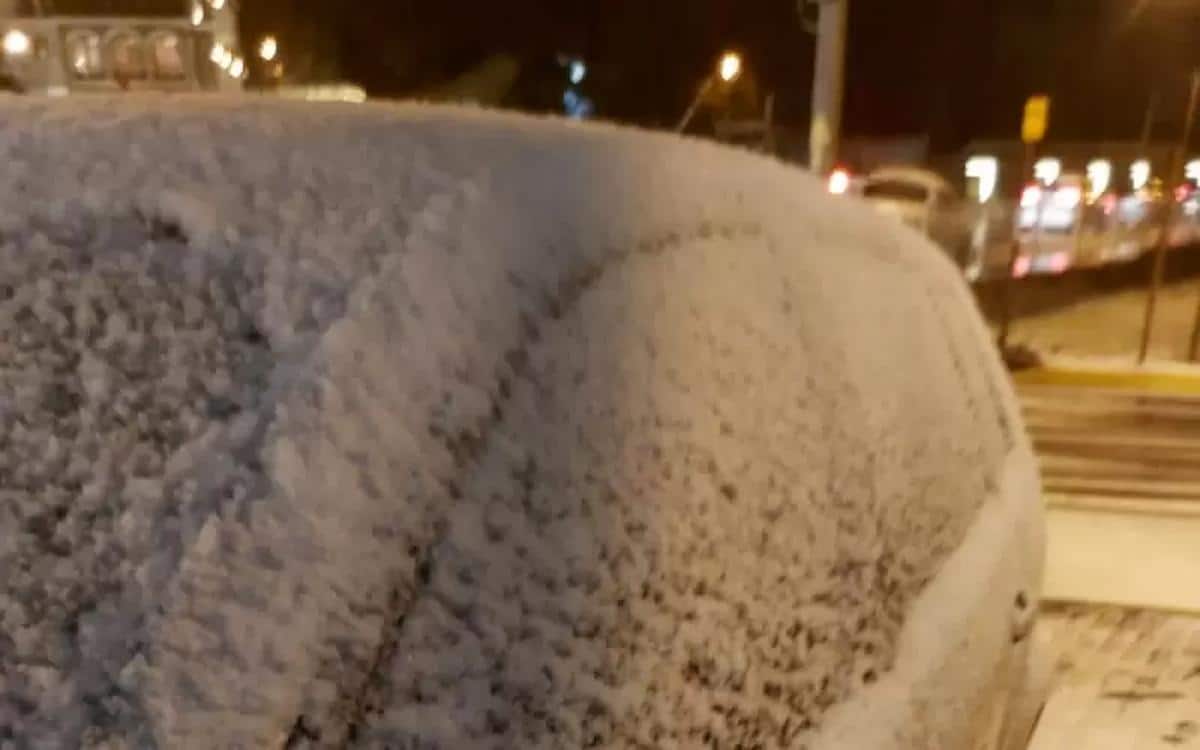 Foto mostra neve cobrindo carro em Gramado.