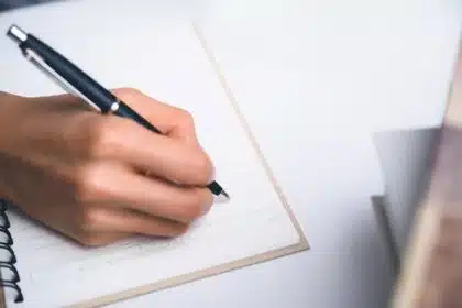 Mão escrevendo em caderno